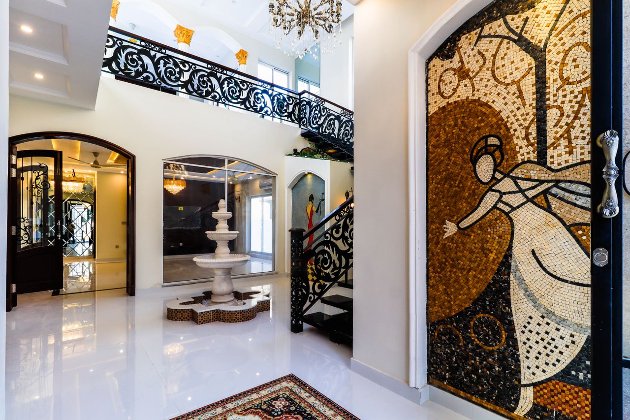 Services Luxurious interior showcasing artistic mosaics and a marble fountain under ornate railings.